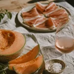 Quel vin servir avec du melon : rosé sec et jambon cru sur table en bois