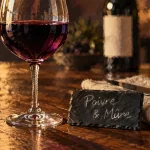Vin syrah rouge, poivre et mûre sur table en bois